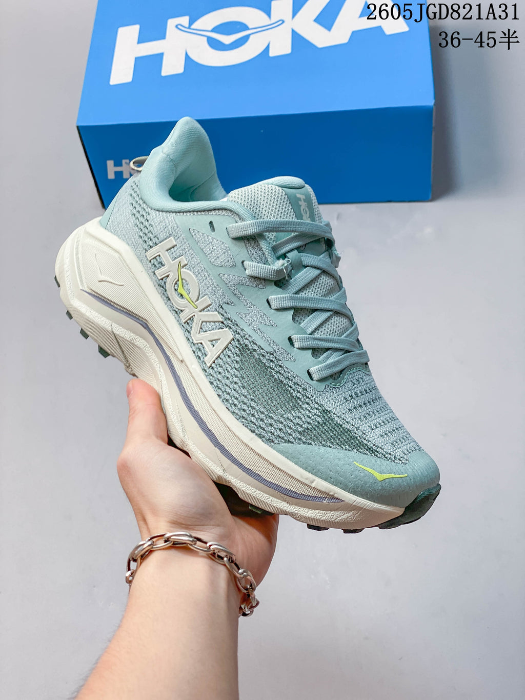 Side view of the shoe showing HOKA branding and light-colored midsole
