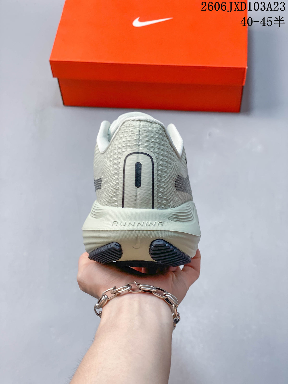 Rear view of a light gray running shoe with a padded heel
