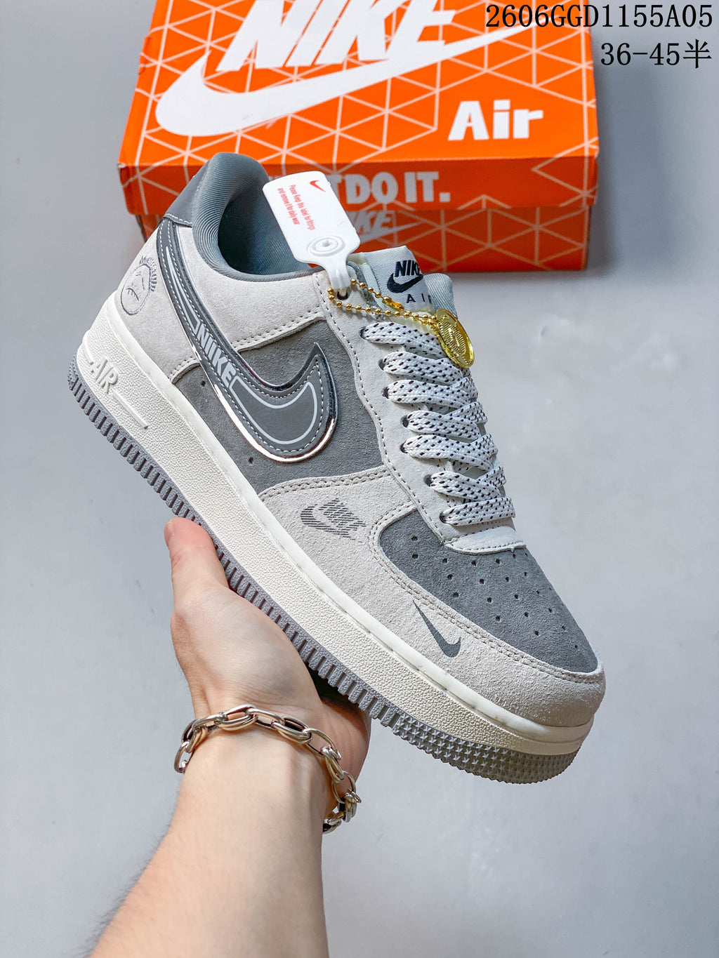 Gray and white low-top sneaker with contrasting overlays and a decorative hanging tag