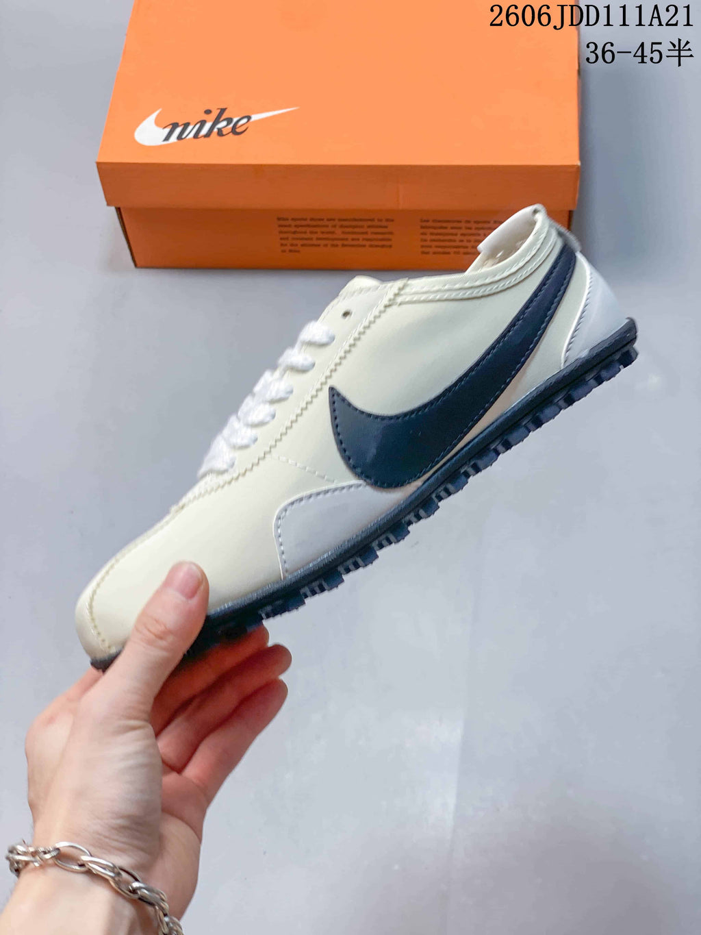 Side view of an off-white Nike Moon Shoe OG Summit sneaker with a dark Swoosh and textured outsole