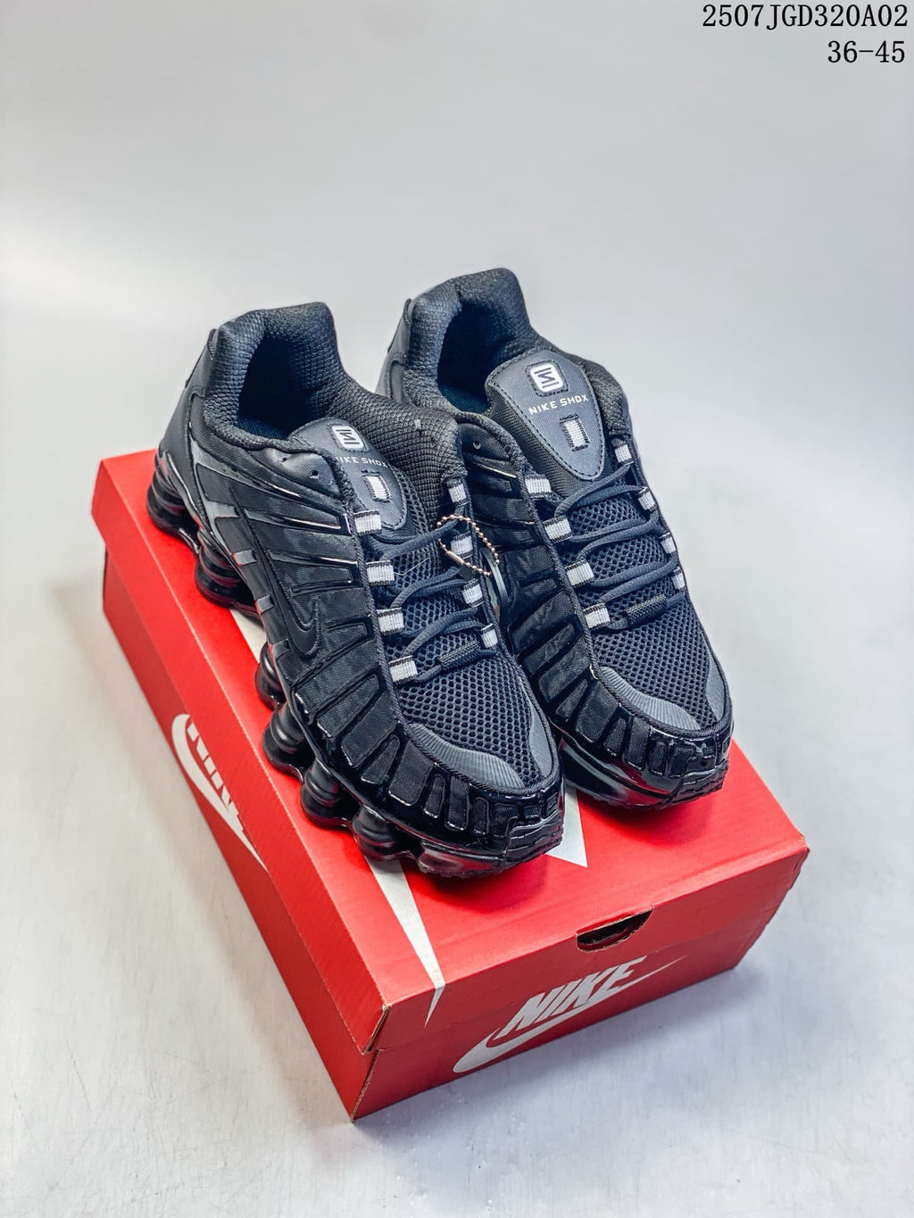 Pair of black Nike Shox TL sneakers displayed on a red shoe box