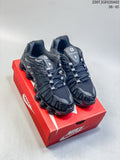 Pair of black Nike Shox TL sneakers displayed on a red shoe box