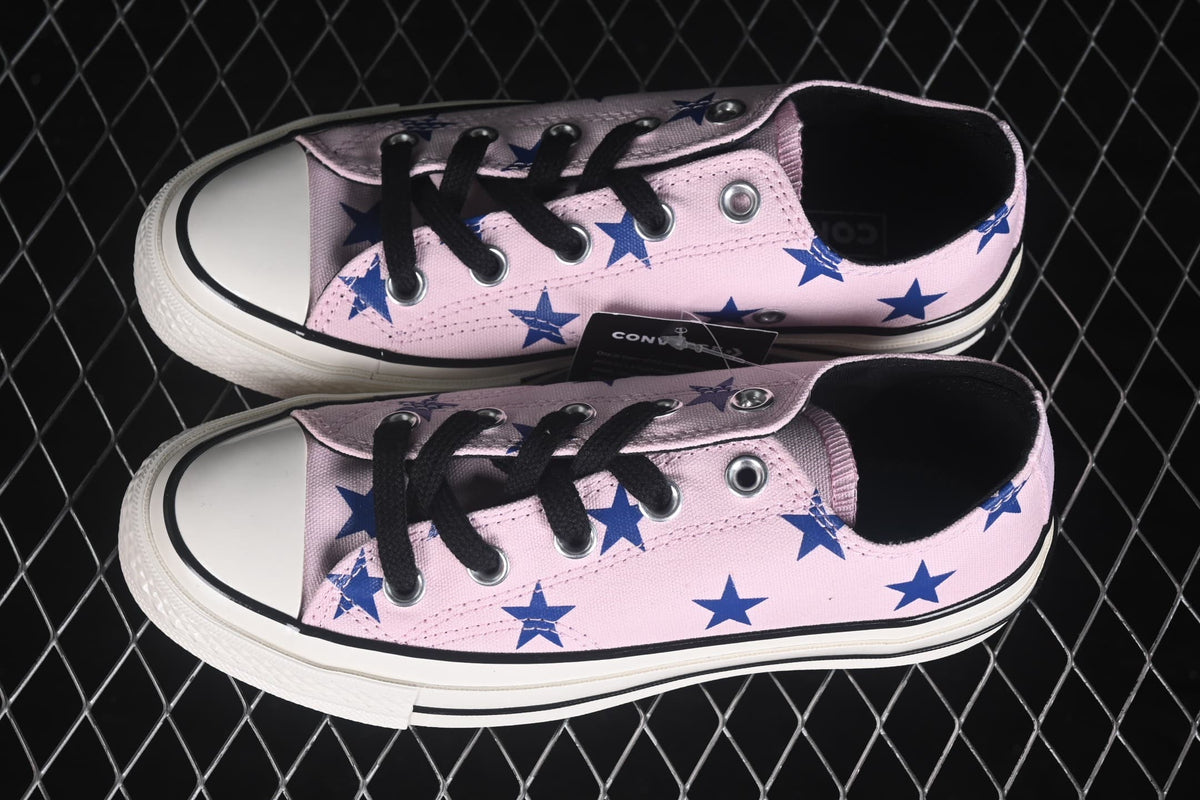 Top-side view of the pair showing the pink star-patterned uppers, black laces, and dark interiors.