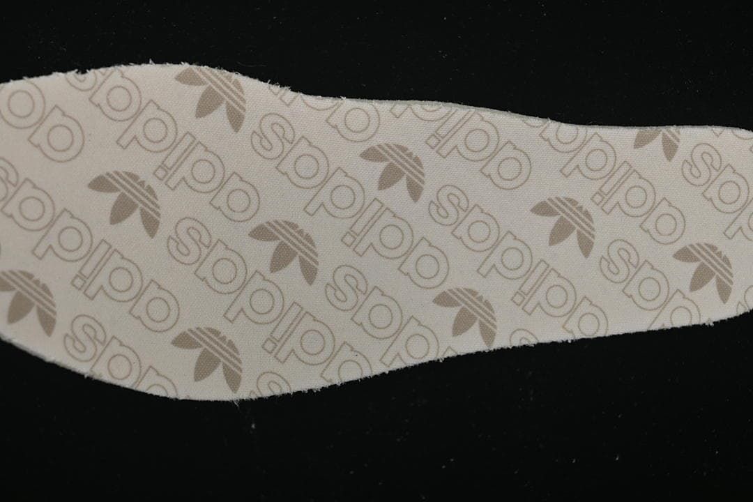 Close-up of the insole with repeating adidas and trefoil pattern.