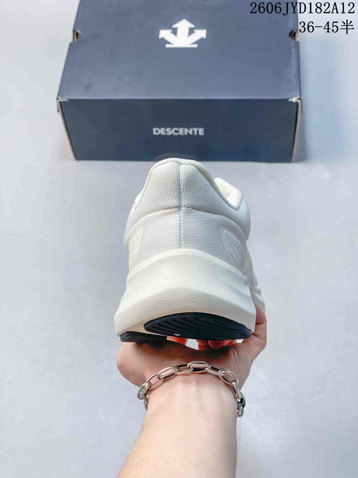 Rear view of the white sneaker showing the heel and raised midsole.