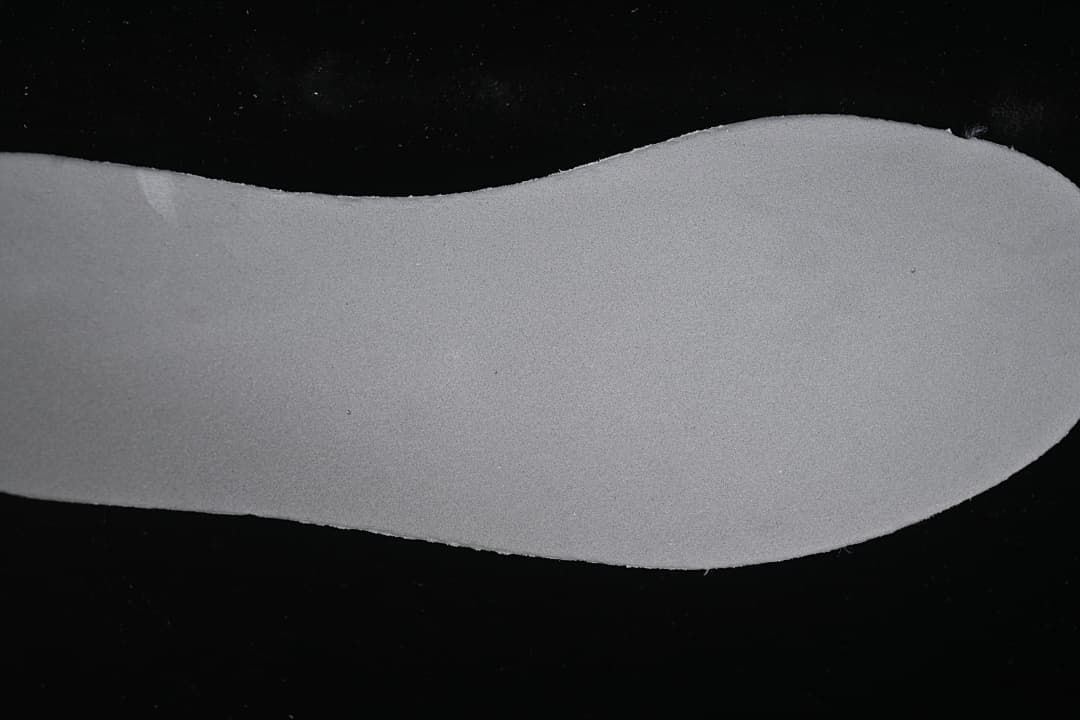 Removable-looking shoe insert photographed on a dark background