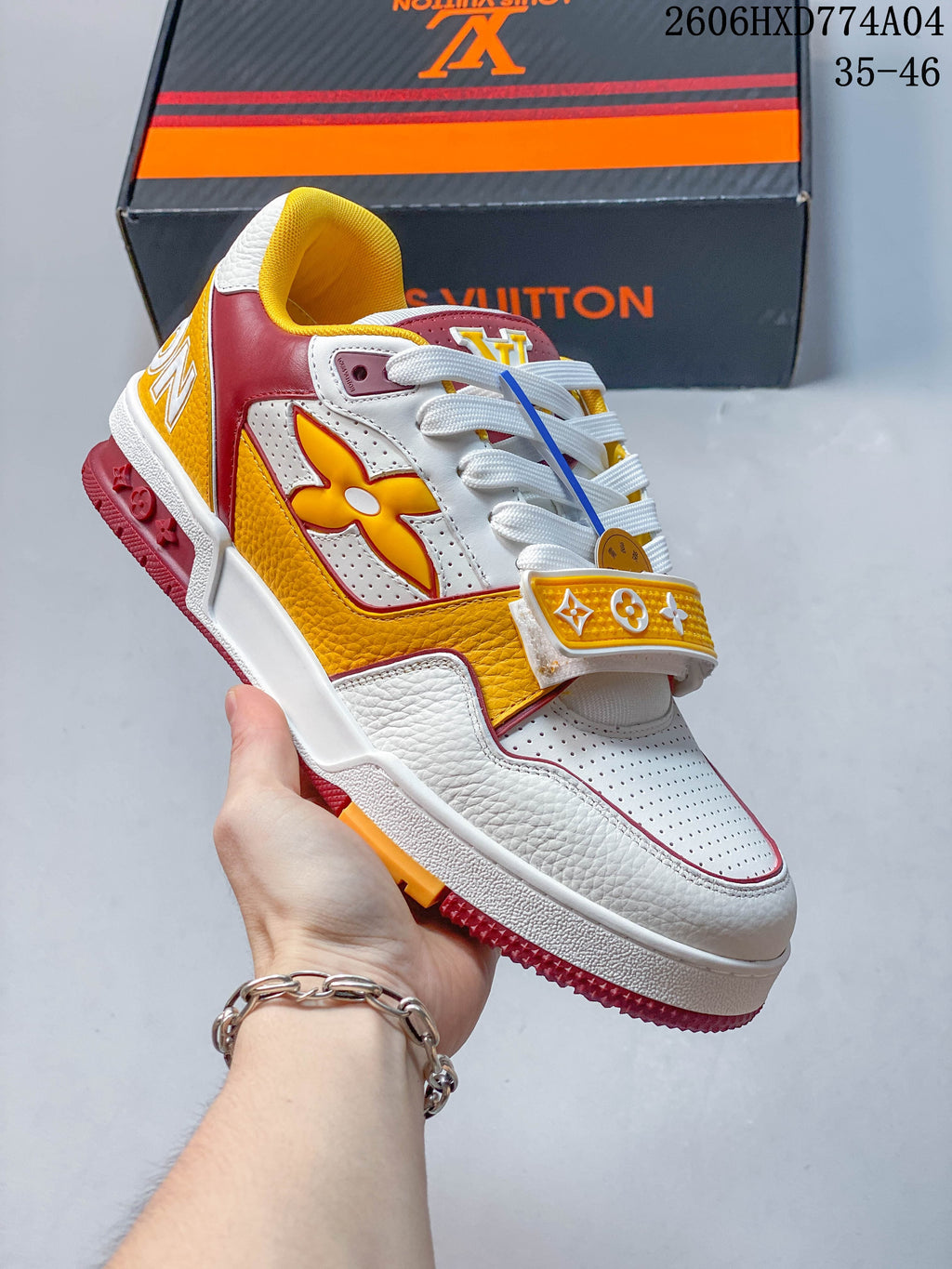 White, orange, and blue low-top sneaker with a bold side motif