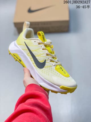 White and yellow Nike trail running shoe with a dark Swoosh and yellow outsole accents.