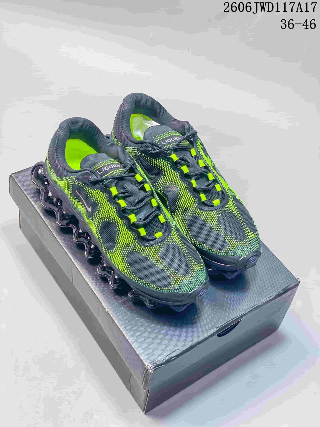 Pair of charcoal and volt-green Nike Air Liquid Max sneakers shown from above on a shoebox