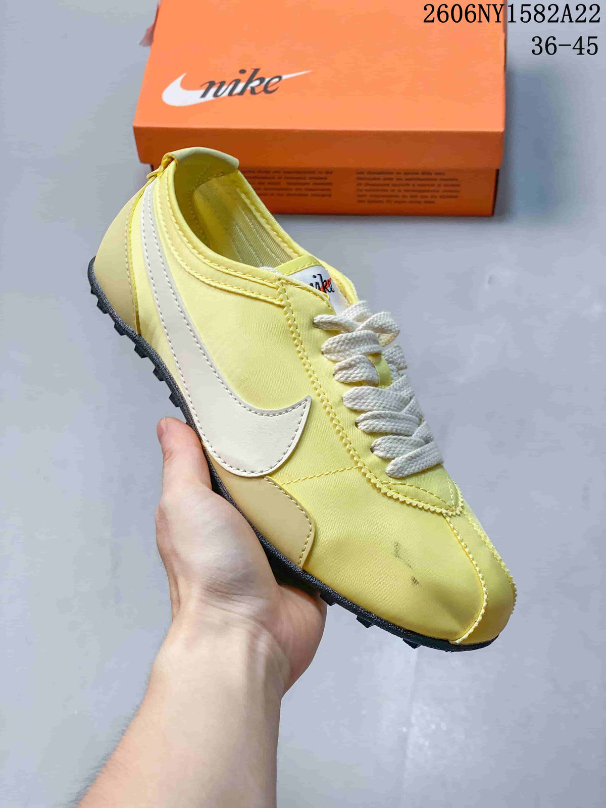 Angled side view of a pale yellow Nike Moon Shoe OG sneaker with white Swoosh detailing