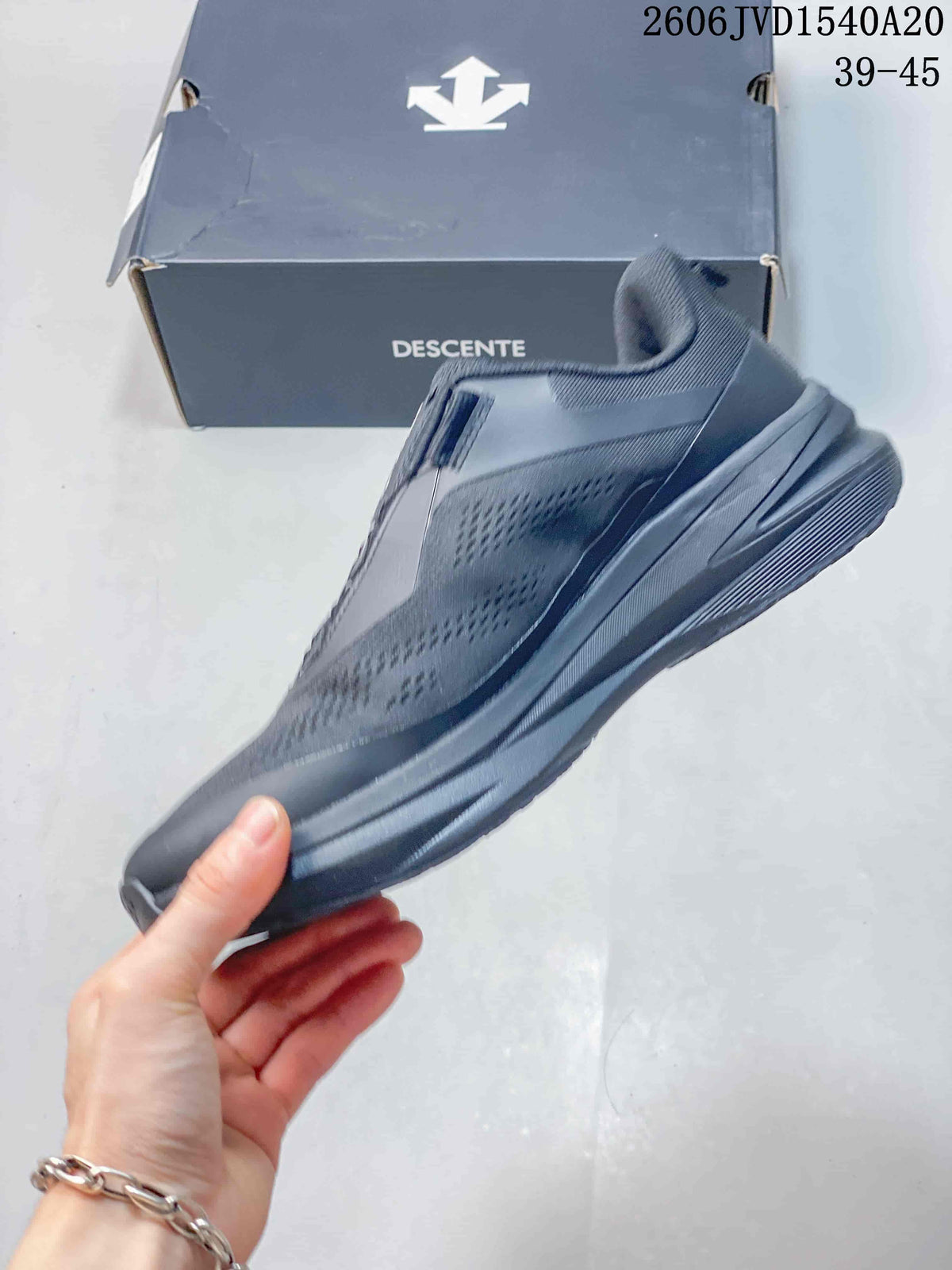 Side profile of a charcoal gray Descente sneaker with a dial-style closure