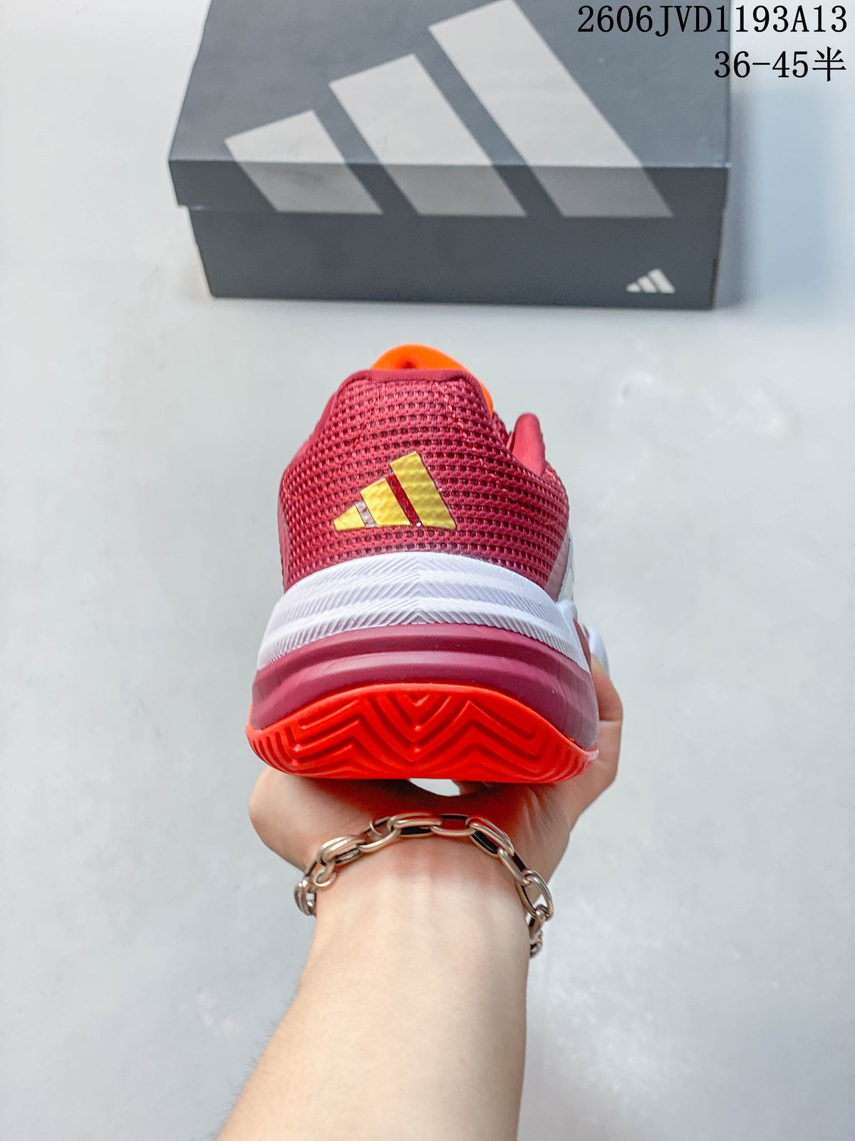 Rear view of the red tennis shoe showing the heel and outsole.