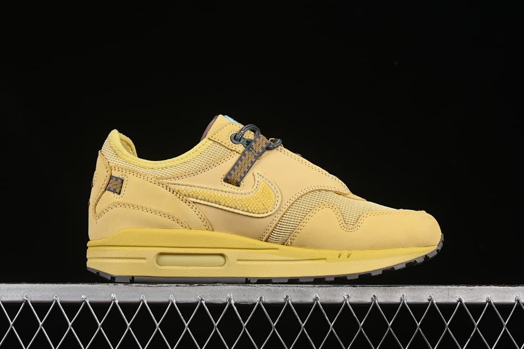 Side profile of the wheat-colored sneaker with layered panels and heel air unit.