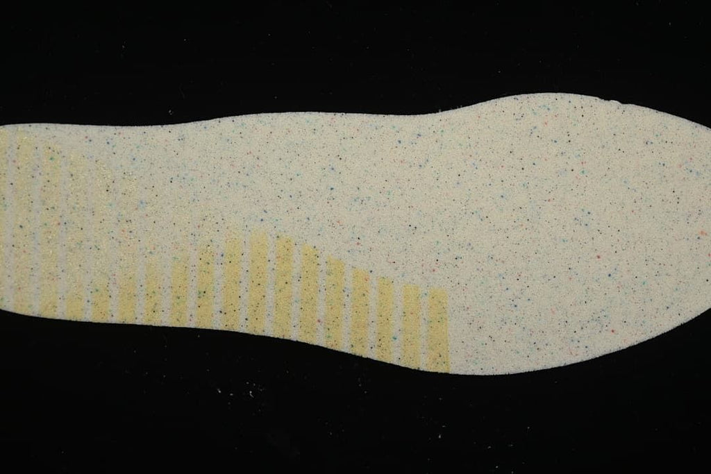 Close-up of the light-colored outsole material with small colored flecks.