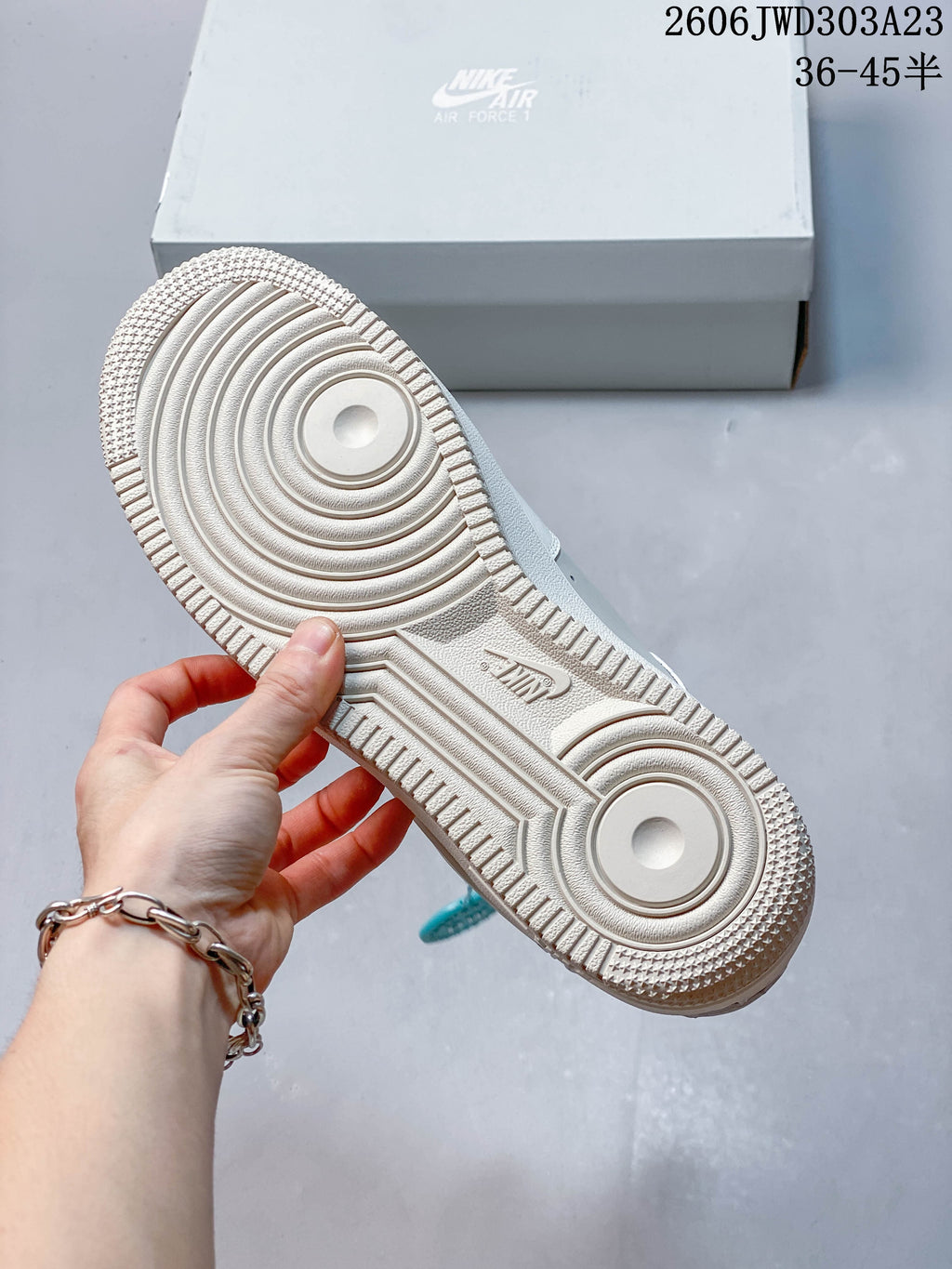 Underside of a white sneaker showing its patterned outsole