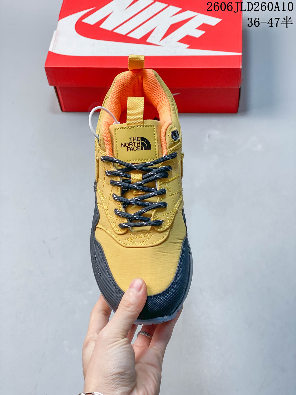 Front view of the sneaker with black laces and orange lining