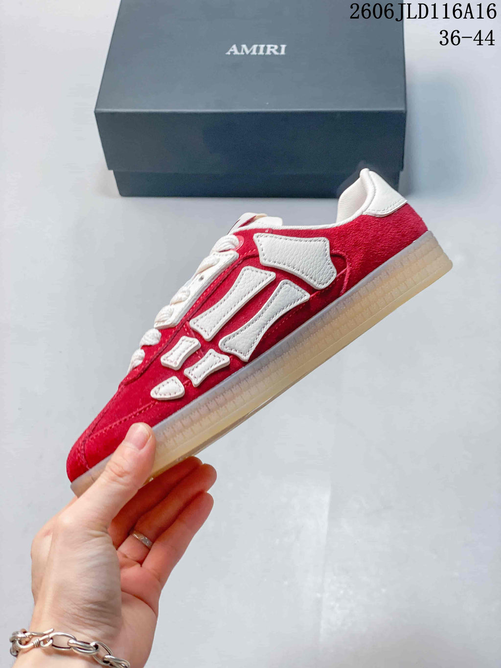 Side view of a red low-top sneaker with white bone-shaped overlays