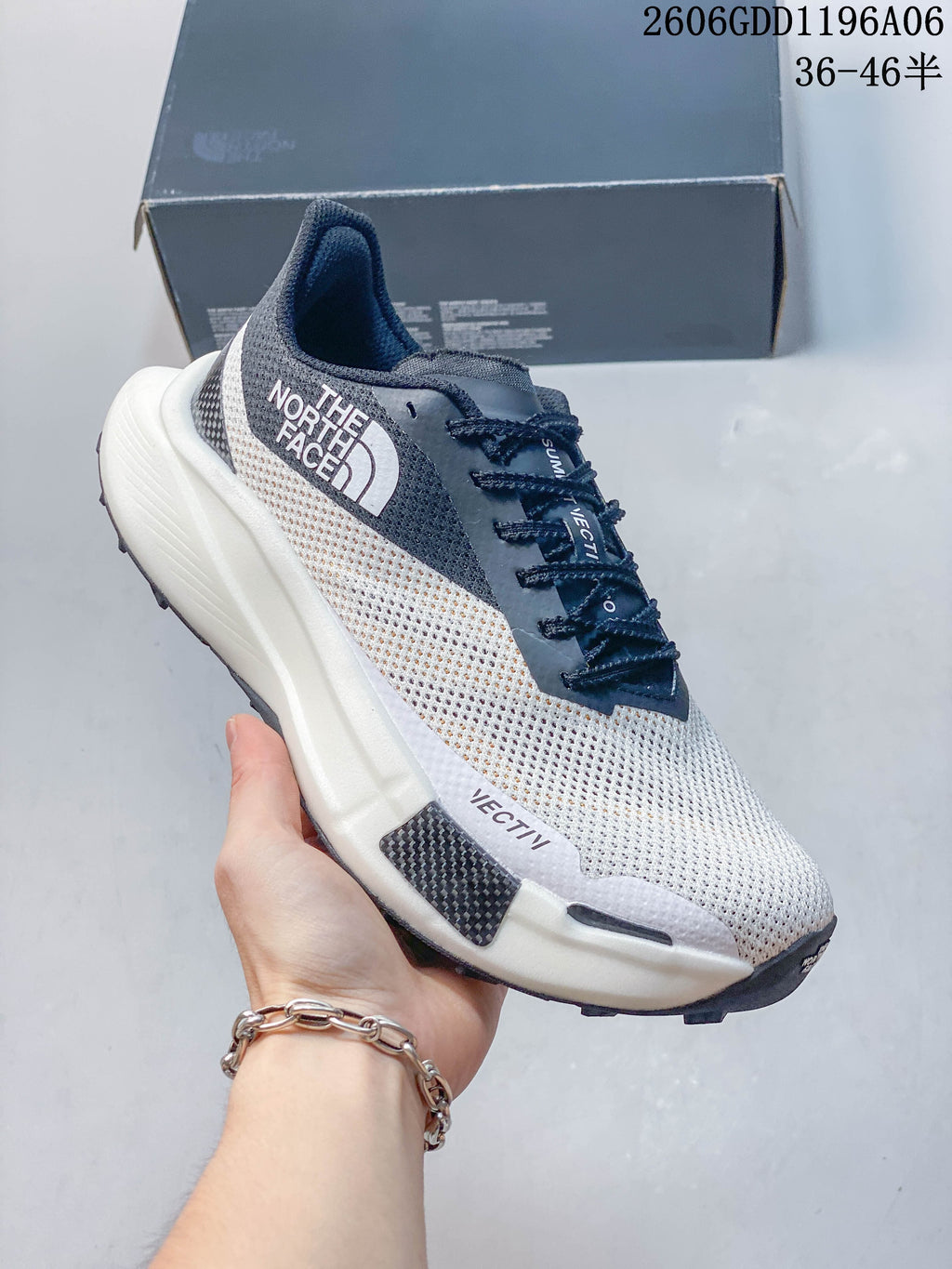 Side view of a white and gray mesh The North Face sneaker with dark laces.