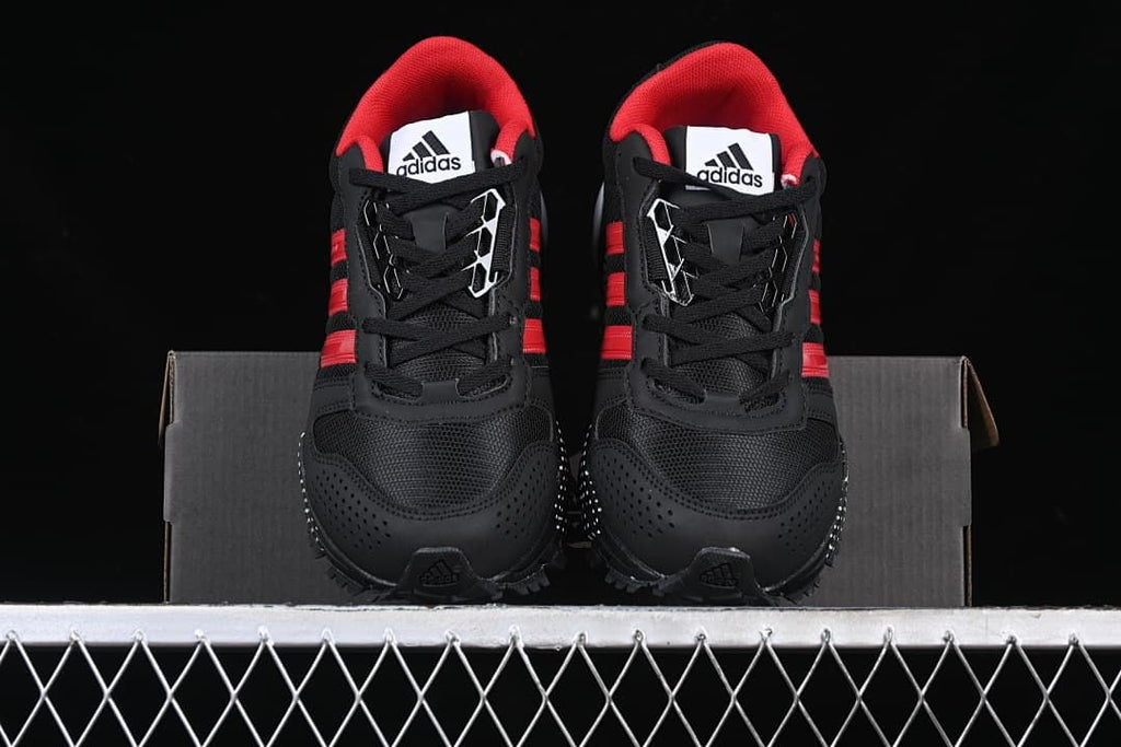 Front view of the pair of black sneakers with red accents.