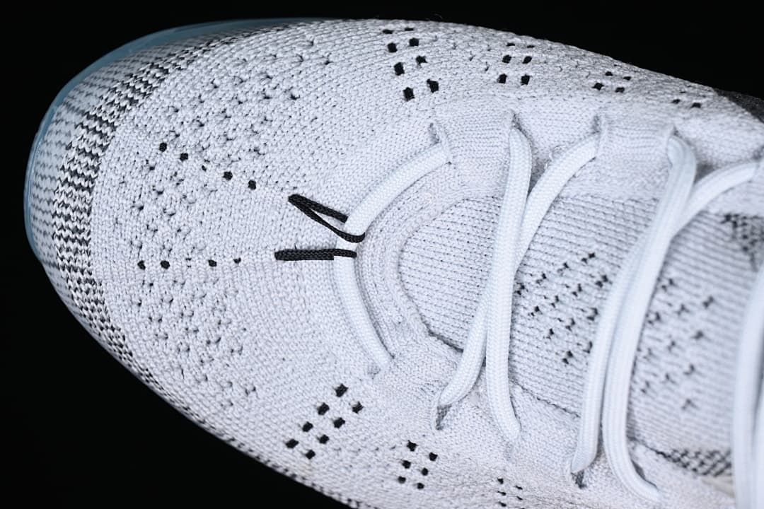 Top close-up of the knit toe box, lace area, and small black details.