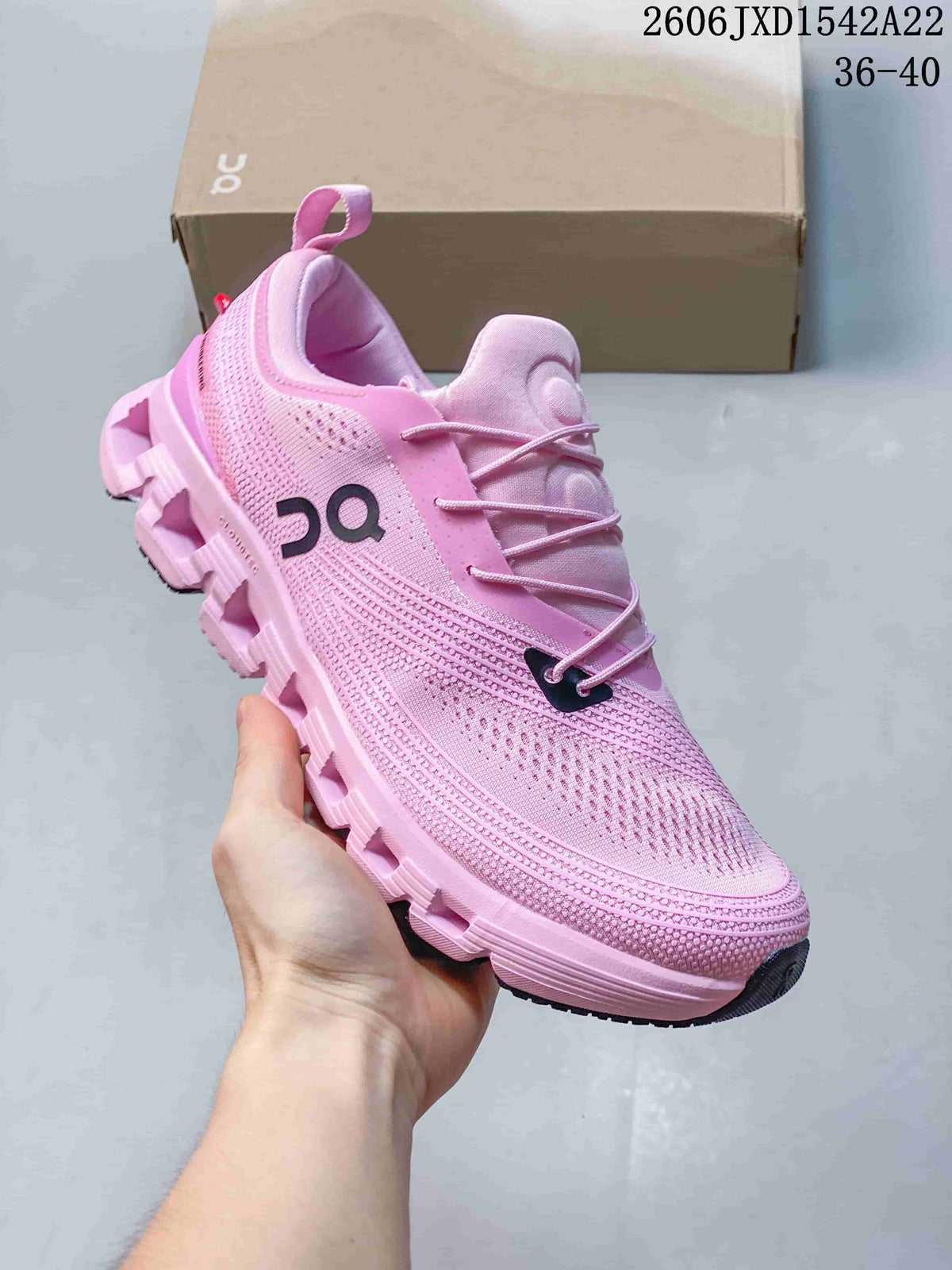 Angled side view of a pink sneaker with dark logo details
