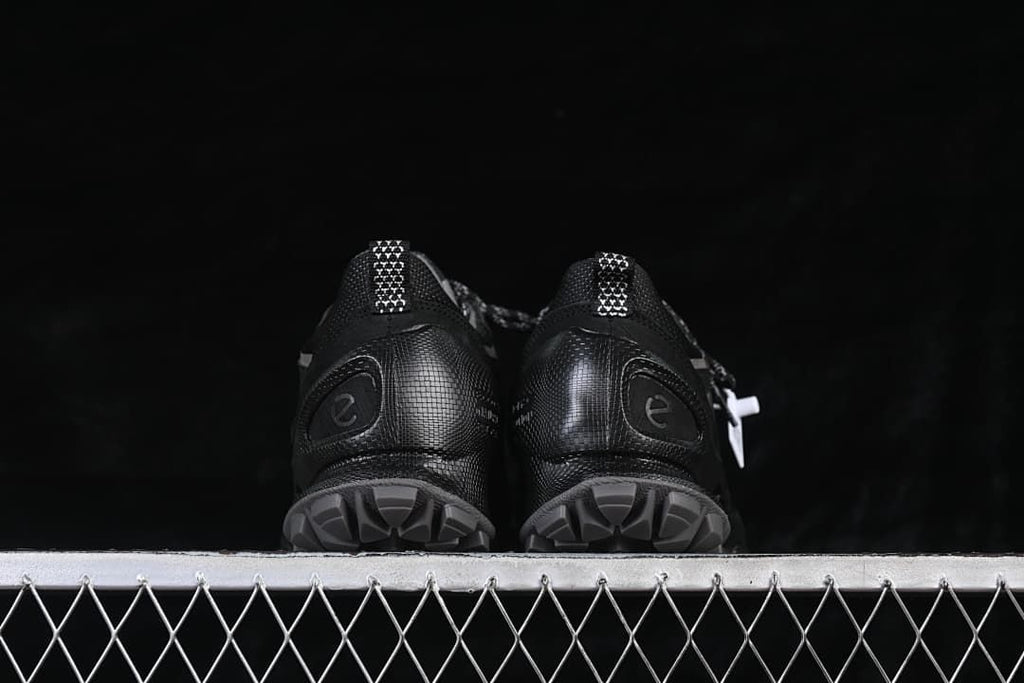 Rear view of both sneakers showing lugged outsoles