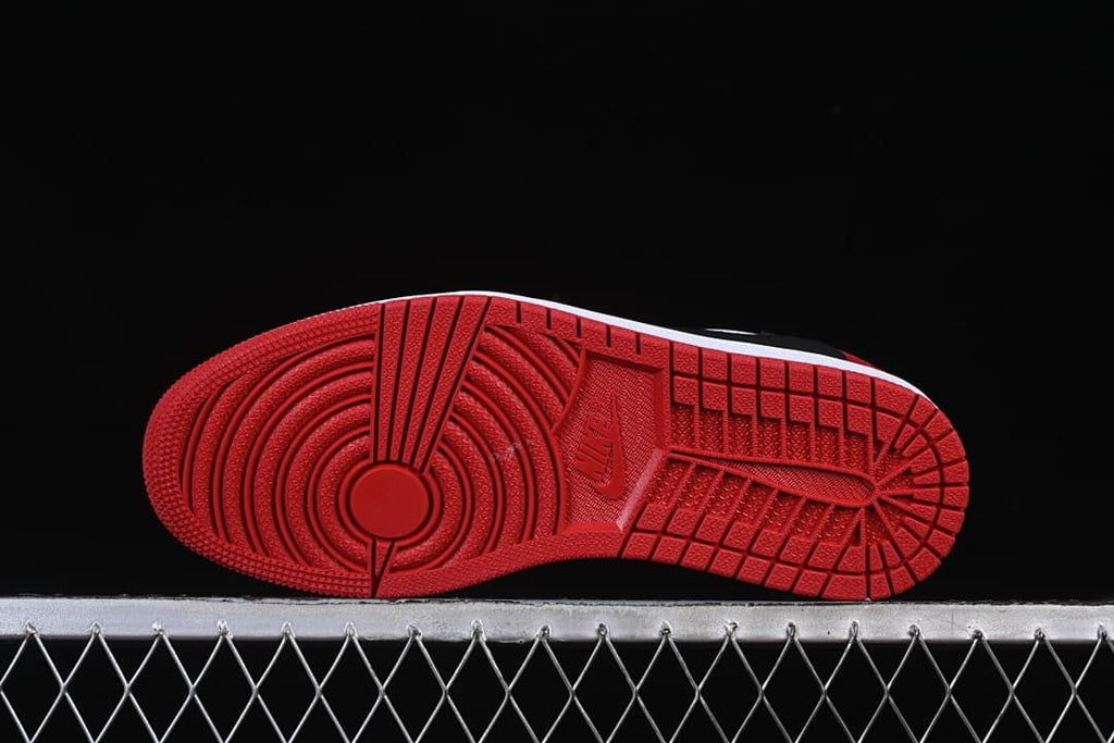 Red outsole with circular forefoot tread and patterned heel tread.