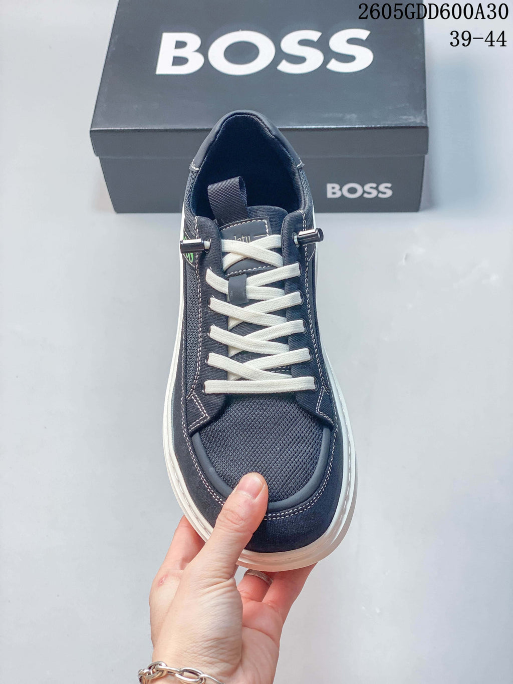 Top-down view of the navy sneaker showing its white laces, textured forefoot panel, and metal-tone lace details; image overlay states sizes 39–44.
