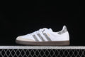 Side view of a white adidas Samba OG sneaker with silver glitter-effect stripes and heel, beige toe overlay, and gum-brown outsole.