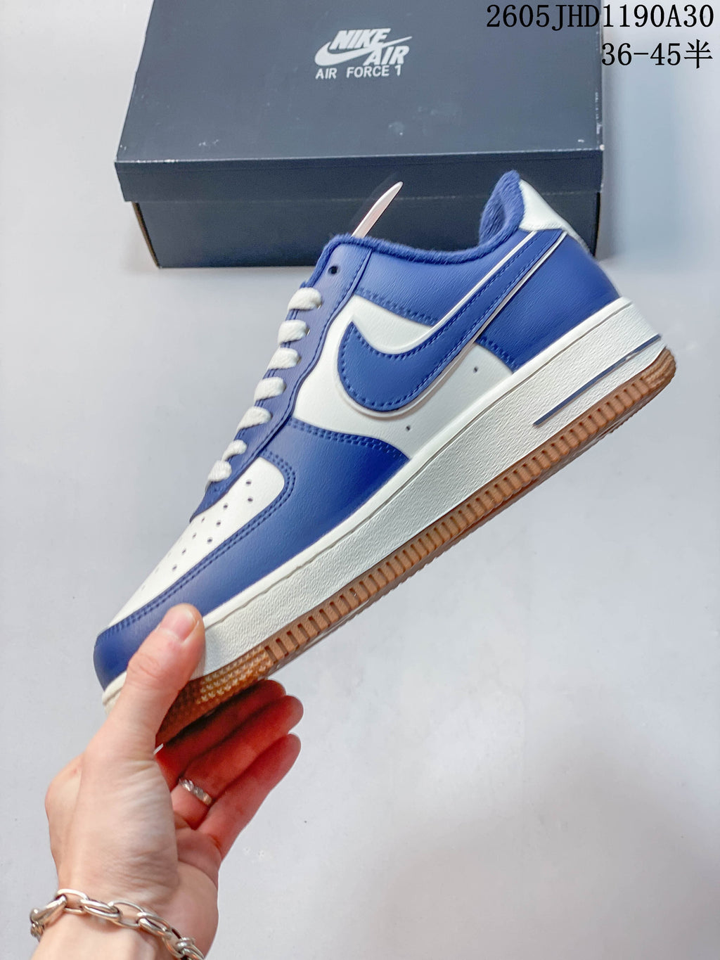 Side view of the blue and white low-top sneaker with gum outsole.