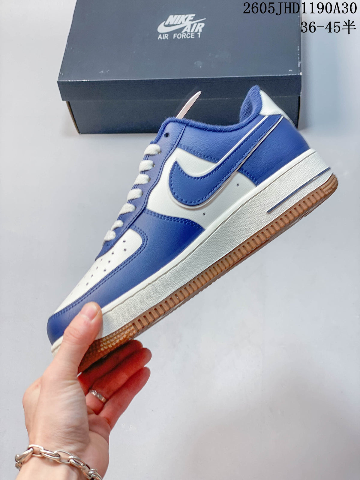 Side view of the blue and white low-top sneaker with gum outsole.