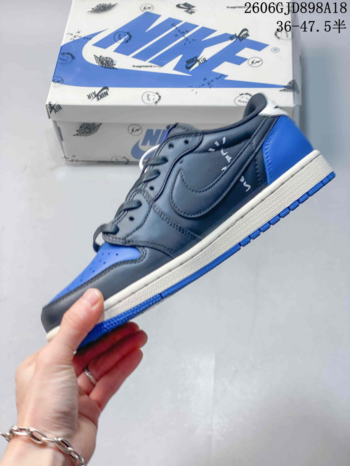 Side view showing dark gray panels, blue heel and toe, and light-colored Swoosh