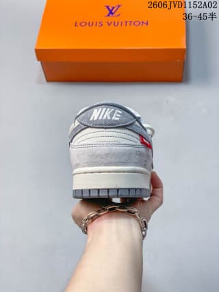 Rear view of a gray and white sneaker with a Nike heel label, positioned in front of an orange Louis Vuitton box.