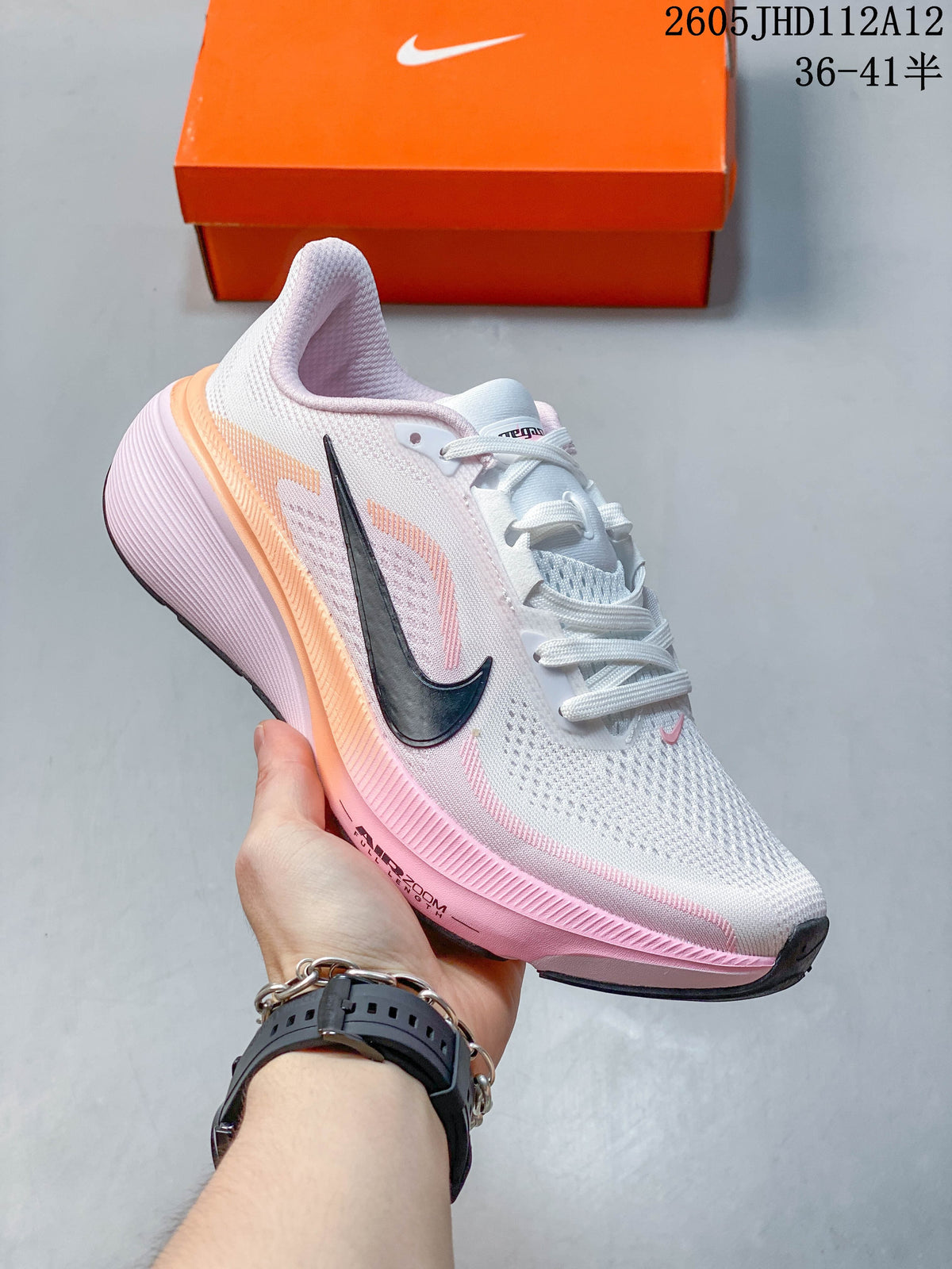Angled side view of the white and pink Nike Air Zoom Pegasus 42 running shoe.