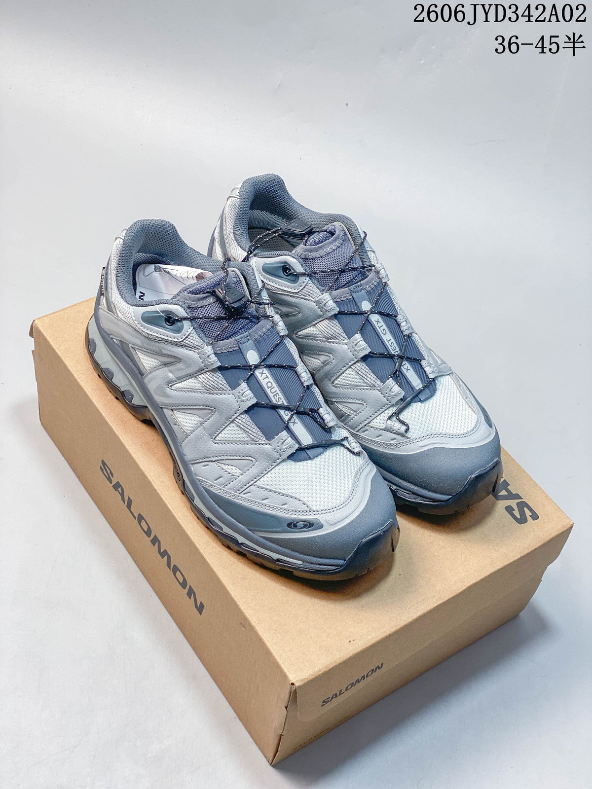 Pair of silver-grey Salomon trail-style shoes with cord lacing