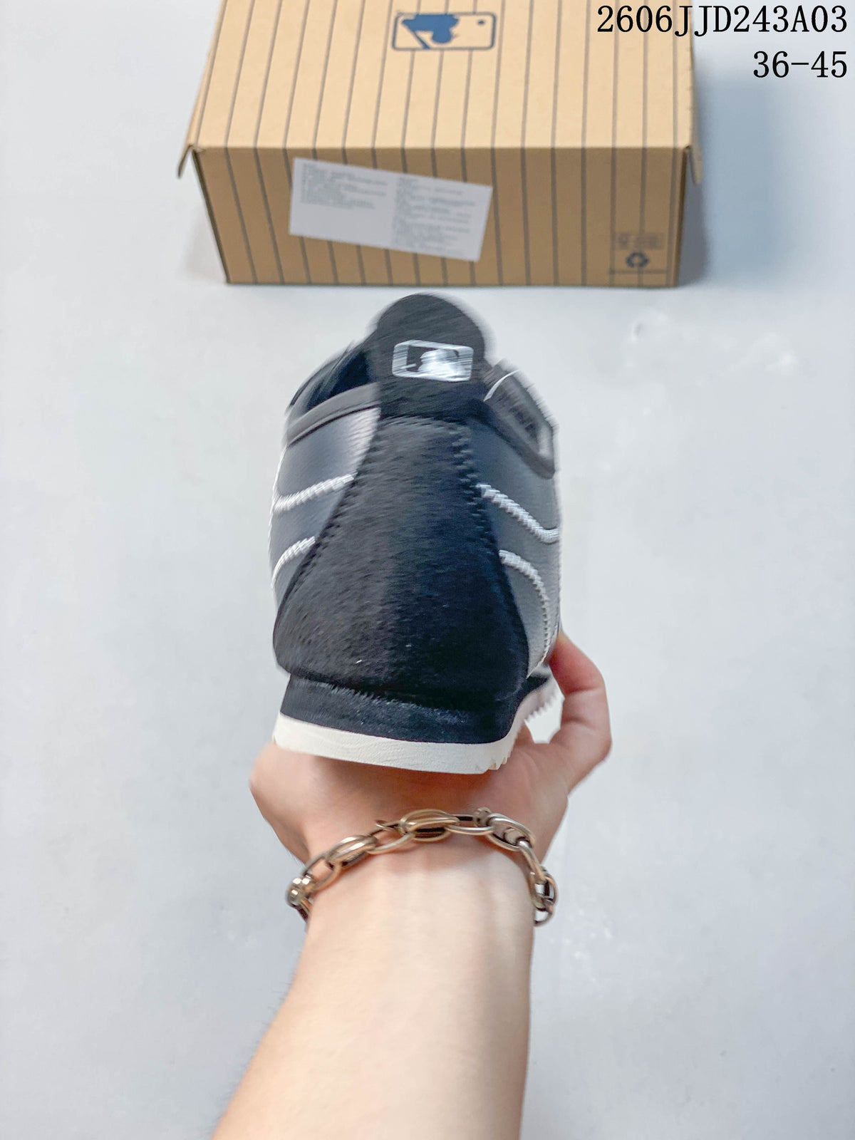 Rear view of a navy sneaker with contrast stitching and a light outsole