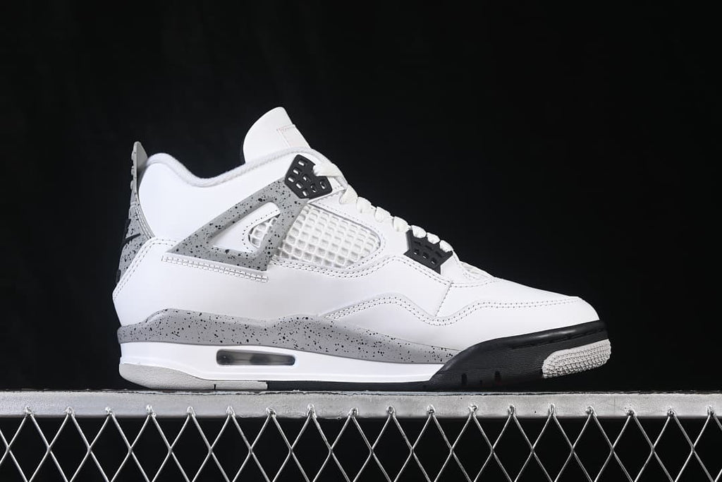 Side view of white Jordan Air Jordan 4 Retro White Cement sneakers with grey speckled panels and black accents