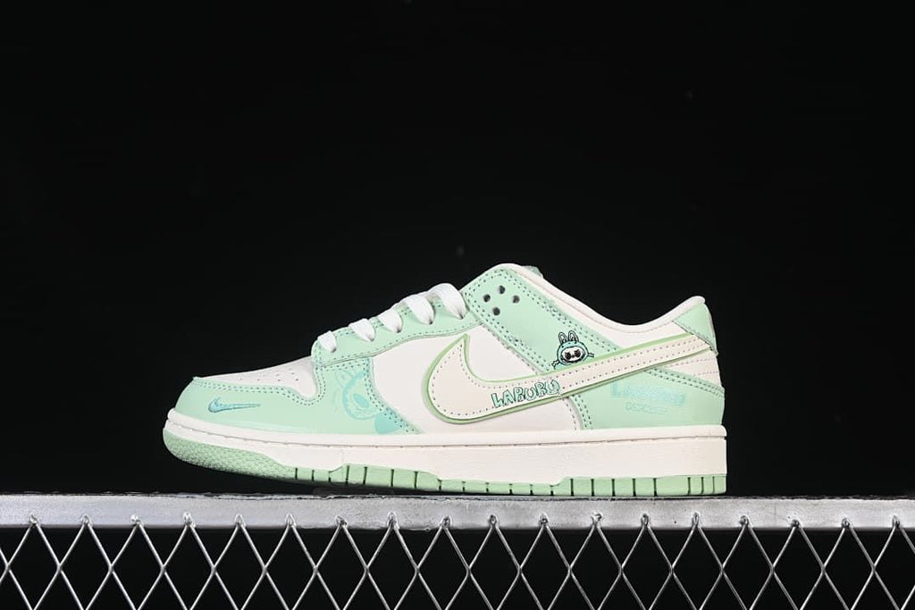 Side view of mint green and off-white Nike SB Dunk Low sneakers with Labubu-themed details