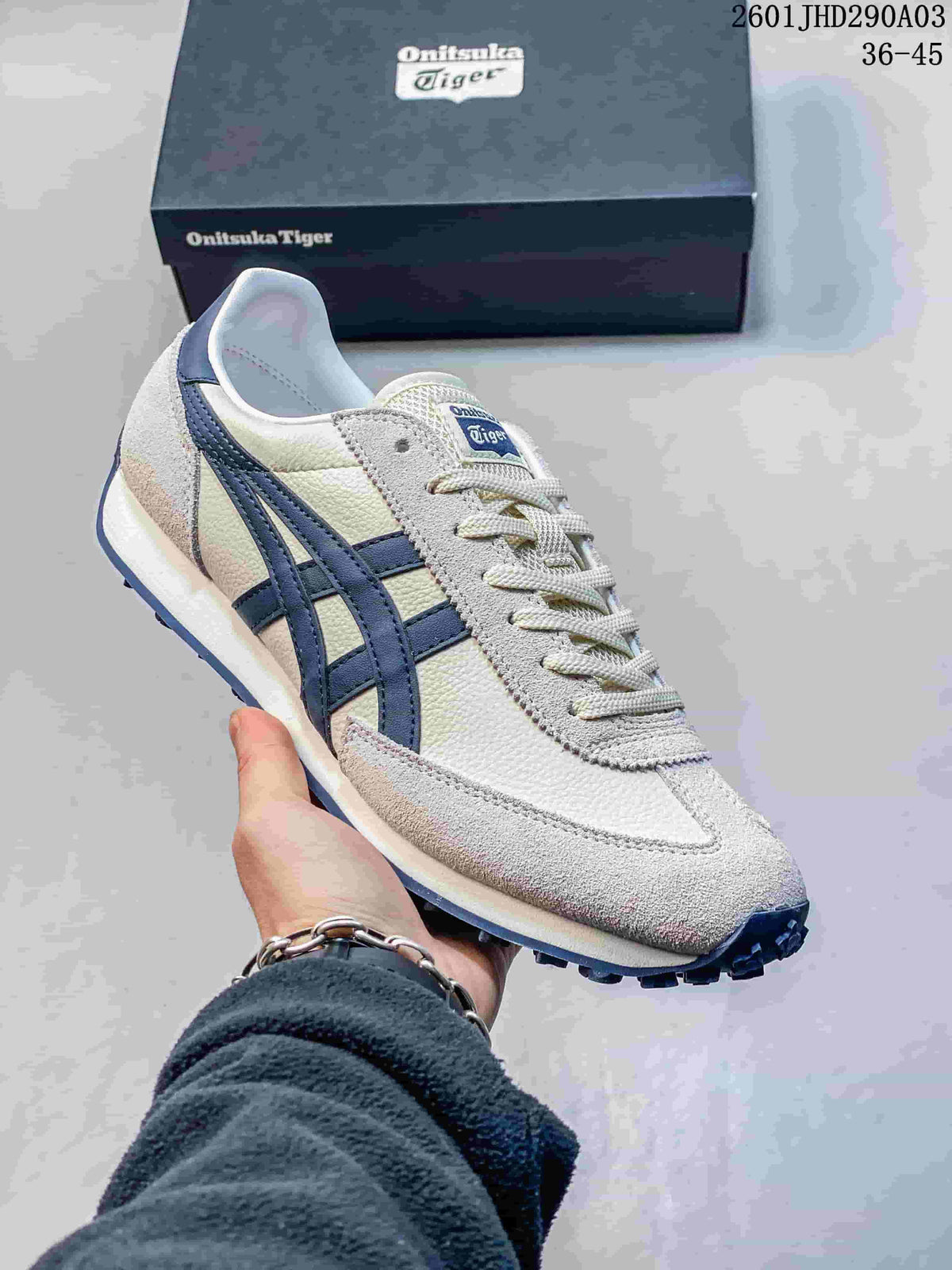 Close-up of a light-colored Onitsuka Tiger EDR 78 sneaker with navy side stripes and a shoebox behind it.