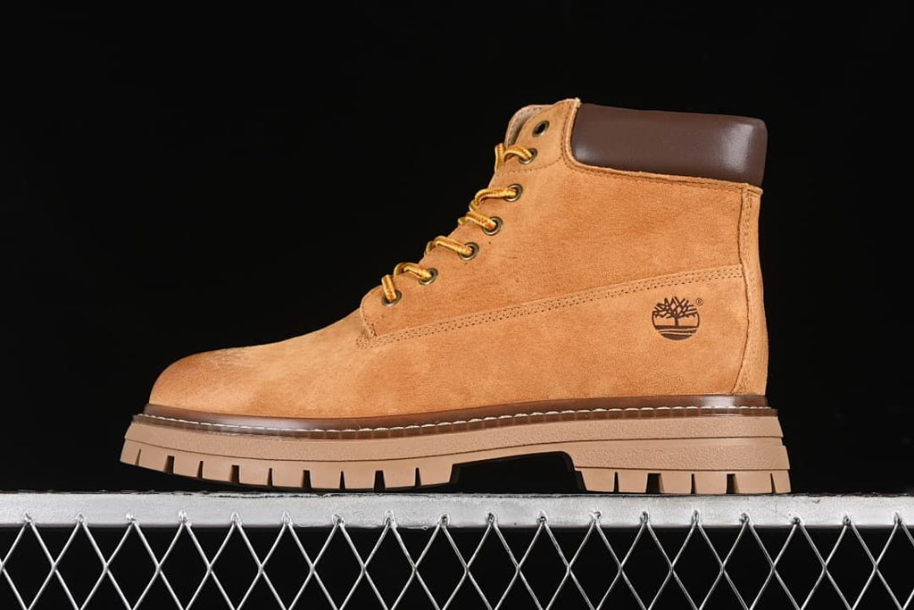 Side view of a yellow-brown Timberland lace-up ankle boot with a chunky lugged sole