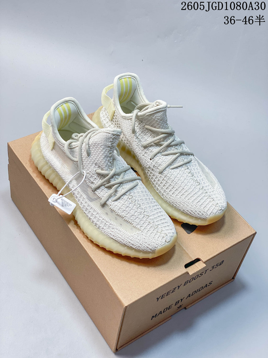 Pair of light cream knit sneakers displayed on a Yeezy Boost 350 box