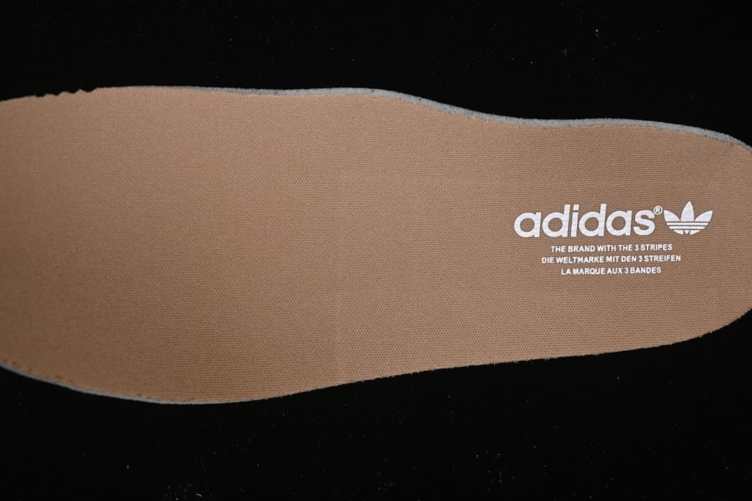 Brown insole with adidas Trefoil branding.