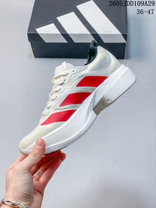 Side view of a white Adidas running shoe with red stripes, a lace-up upper, and a raised white sole.