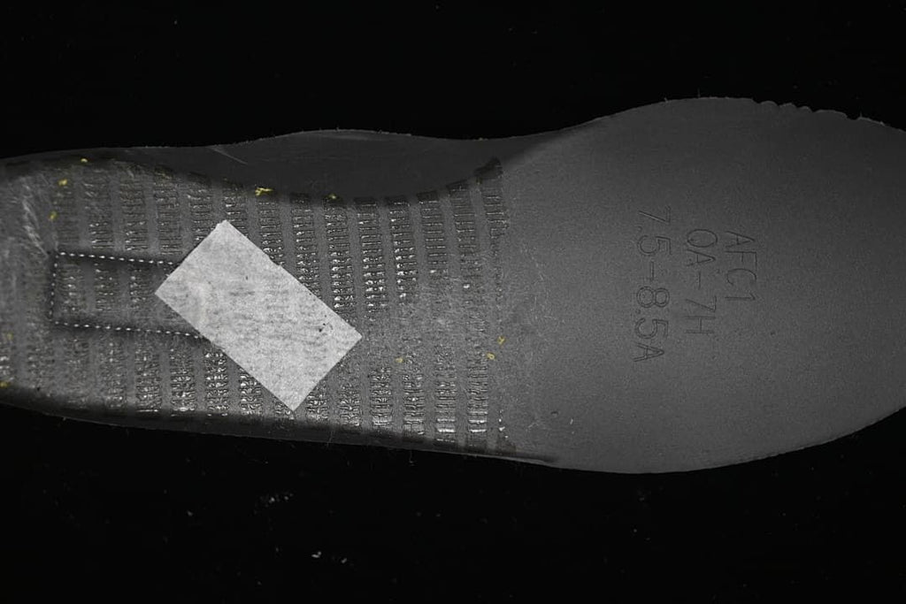 Close-up of the sneaker outsole with molded lettering and tread details.