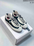 Pair of black and ivory low-top trainers with speckled laces, shown on a box.