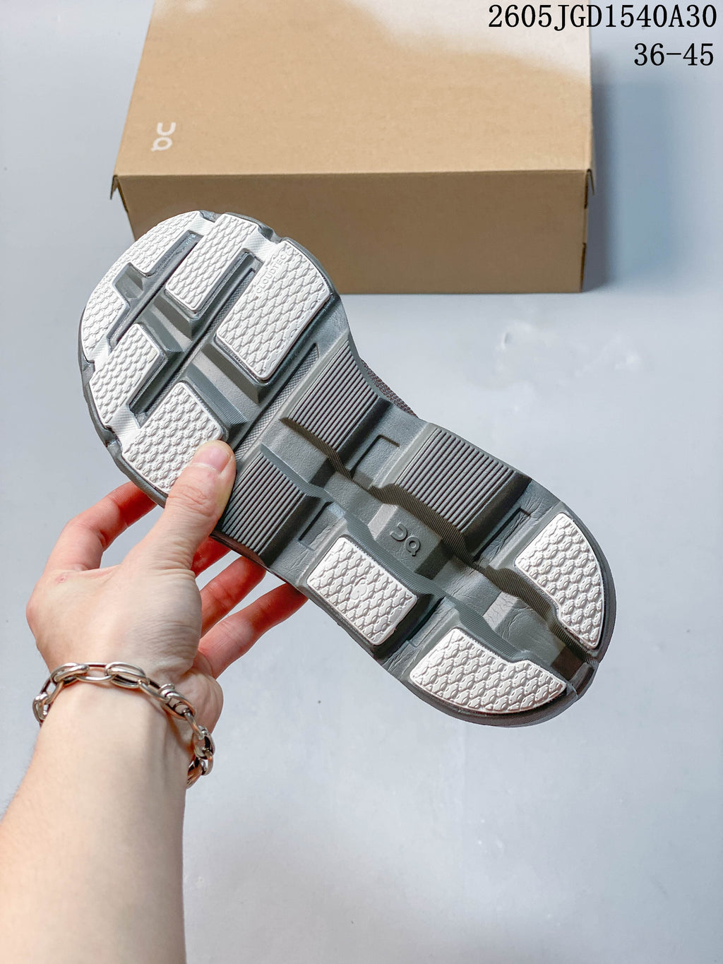 Underside view of the sculpted gray sneaker sole with textured contact sections