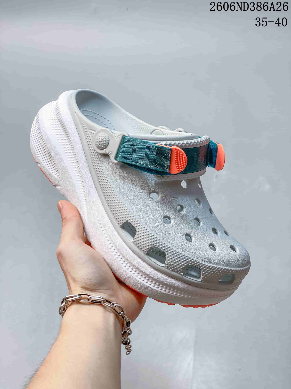 White clog sandal with teal and orange strap accents and orange sole details