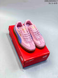 Pair of pink PUMA Club II Era low-top sneakers with blue side stripes and gum-colored soles, displayed on a red shoe box