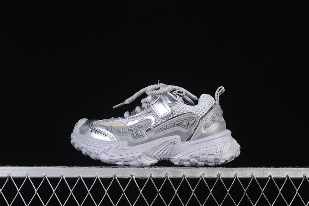 Side view of a silver and light gray chunky children’s sneaker
