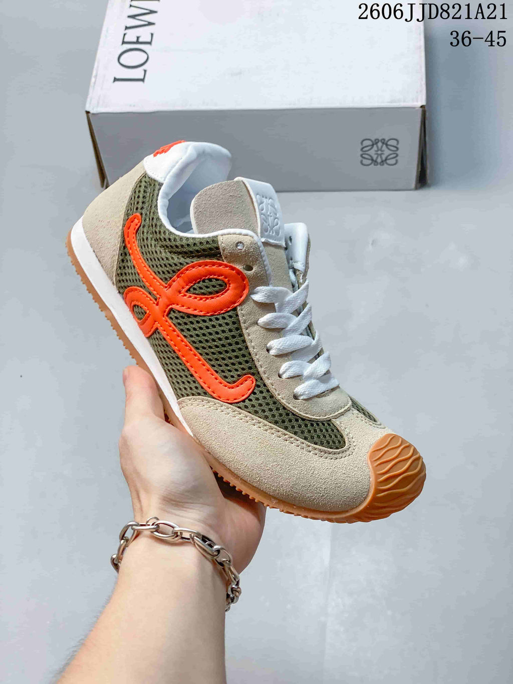 Side view of a cream and olive sneaker with orange side detailing and mesh panels